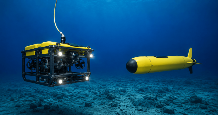 AUV vs ROV comparison showing a tethered remotely operated vehicle and an autonomous underwater vehicle underwater